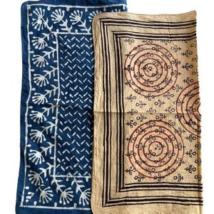 May include: Two cotton fabric squares with a blue and white geometric pattern and a beige square with a brown and red geometric pattern.