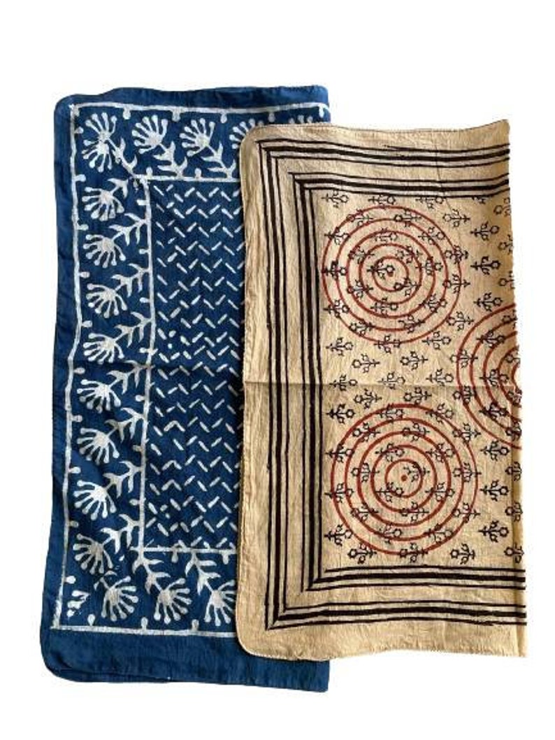 May include: Two cotton fabric squares with a blue and white geometric pattern and a beige square with a brown and red geometric pattern.