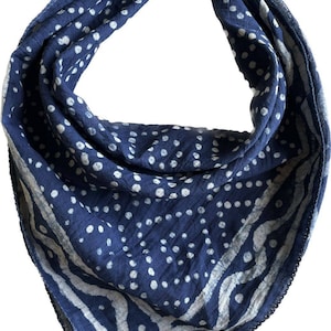 May include: A blue bandana with a white polka dot pattern and a white border. The bandana is folded and tied in a knot.