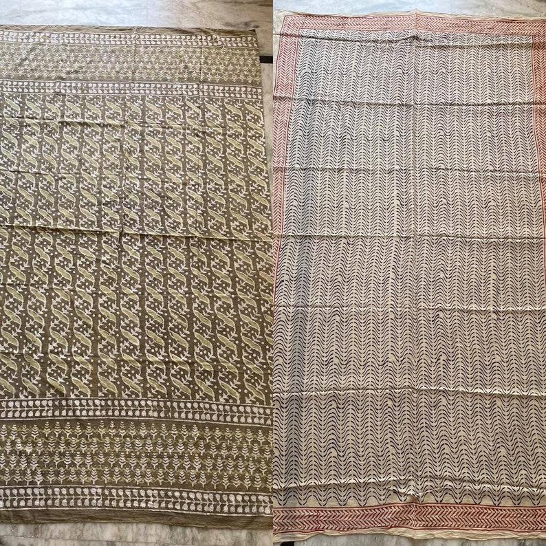 May include: Two patterned textiles. One is olive green with a repeating white and olive design. The other is off-white with a repeating black and off-white design. Both have decorative borders.