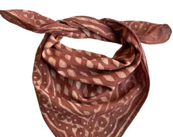 Könnte beinhalten: Ein rostiges Bandana mit einem weißen geometrischen Muster. Das Bandana ist zu einem Dreieck gefaltet.