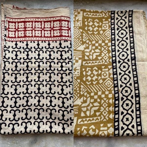 May include: Two fabric squares with different geometric patterns. The square on the left has a black and white pattern of repeating swirls. The square on the right has a mustard yellow and white pattern of geometric shapes.