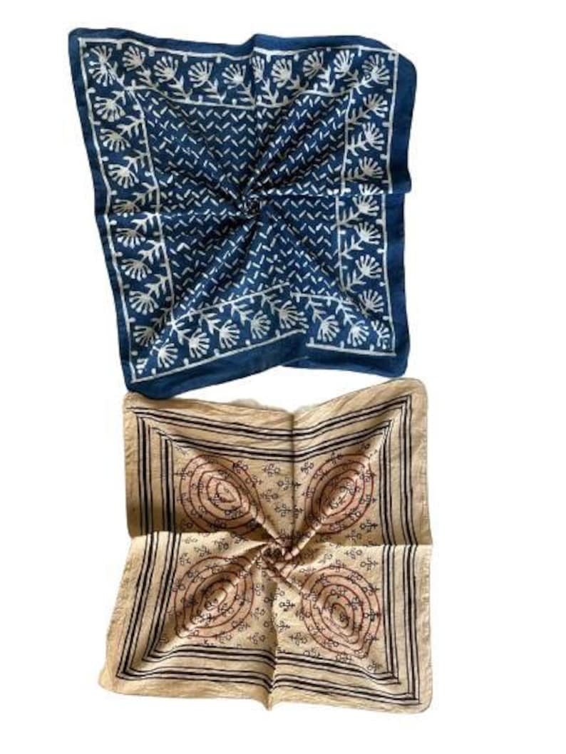 May include: Two square cotton bandanas, one blue with a white floral pattern and the other beige with a brown floral pattern.