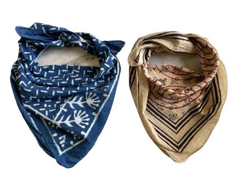 May include: Two cotton bandanas with different patterns. One is blue with a white floral design and the other is beige with brown and red stripes and a floral design.