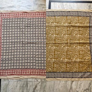 May include: A beige cotton fabric with a black and white geometric pattern on one side and a beige and brown geometric pattern on the other side.