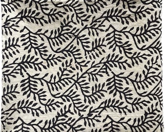 May include: A white fabric with a black leaf pattern. The leaves are stylized and resemble a fern.