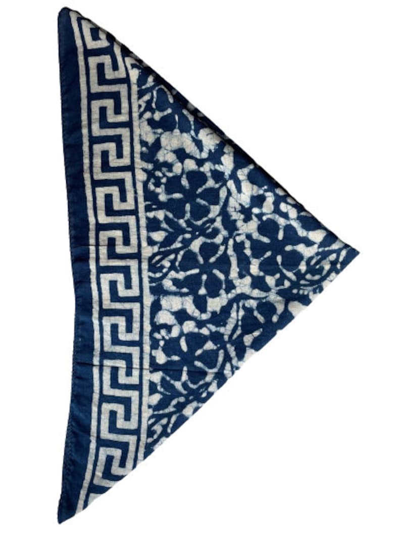 May include: A blue bandana with a white floral pattern and a white Greek key border.