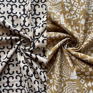 May include: Two fabric swatches with different patterns. The first swatch is white with a black geometric pattern. The second swatch is brown with a white geometric pattern.