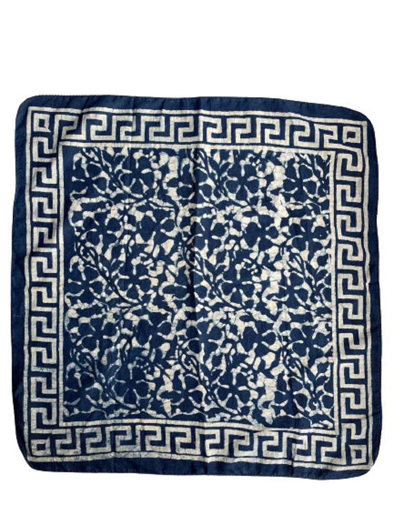 May include: A blue and white cotton bandana with a floral pattern and a white Greek key border.