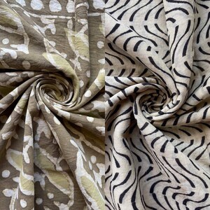 May include: Two sections of fabric with different patterns. The left section has a brown background with white and light green floral and dot designs. The right section has a beige background with black curved line patterns. Both sections are swirled.