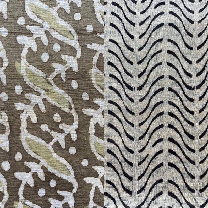 May include: Close-up of a textile with two distinct patterns. One side features white leaf and dot designs on a brown background. The other side has black wavy lines on a beige background. The fabric has a textured appearance.