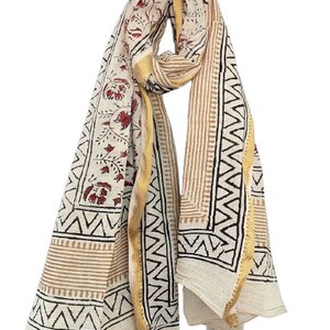 May include: A white cotton scarf with a floral print in shades of red and brown. The scarf has a gold border and a geometric pattern in black and brown.