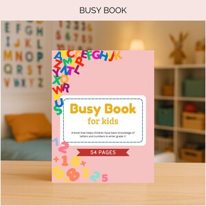 Op de afbeelding: Een roze "Busy Book for kids" met kleurrijke letters en cijfers. De omslag toont de titel in geel en wit, met een beschrijving eronder. Het boek heeft 54 pagina's en is ontworpen om kinderen basiskennis te leren.