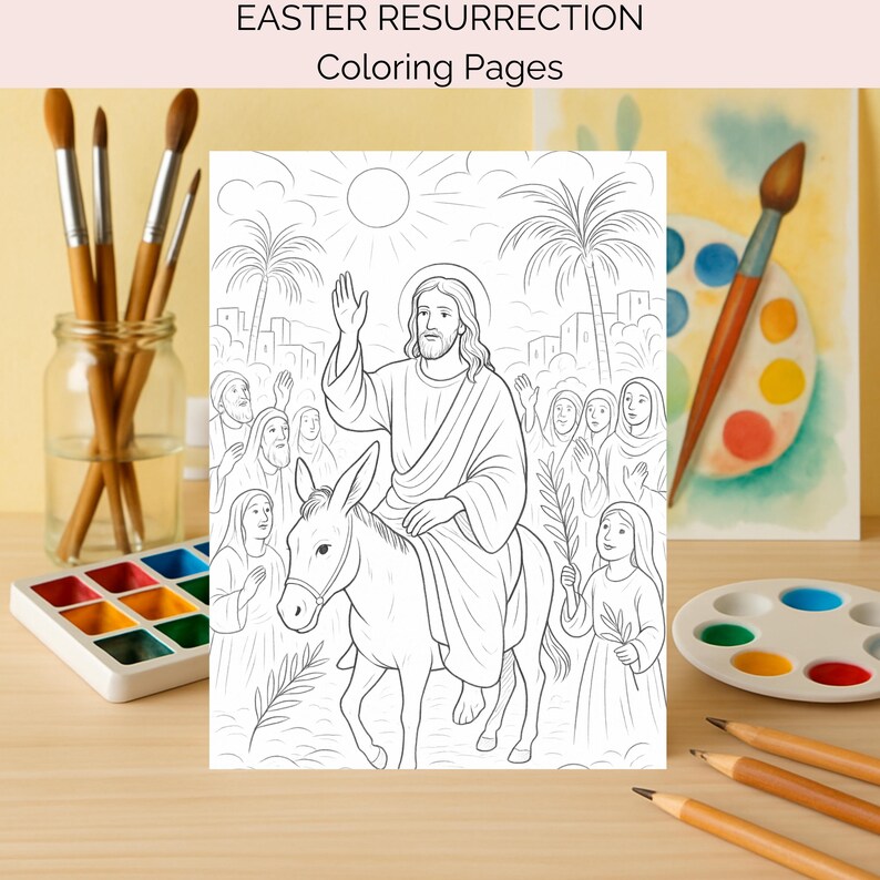 May include: Black and white colouring page with the text "EASTER RESURRECTION Coloring Pages". The illustration shows Jesus riding a donkey, with people waving and palm branches. Paintbrushes, watercolour paints, and pencils are visible.