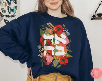 May include: A navy blue sweatshirt featuring a floral design and the Hebrew words "Chai" and "Shalom" in white lettering.