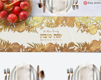 Könnte beinhalten: Goldener Tischläufer mit weißem Hintergrund und einem goldenen Design aus Granatäpfeln, Blättern und den hebräischen Worten "Shana Tova", was "Frohes Neues Jahr" bedeutet. Der Text "The Klein Family" ist ebenfalls enthalten.