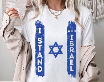Könnte beinhalten: Weißes T-Shirt mit einem blauen, abgenutzten Grafikdruck eines Davidsterns und dem Text "I Stand With Israel".