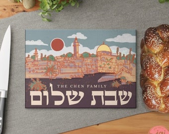May include: A blue and brown illustrated cutting board with a cityscape of Jerusalem, a red sun, and the text "THE CHEN FAMILY שבת שלום" in Hebrew.