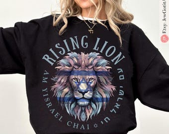 Op de afbeelding: Zwart sweatshirt met een leeuwenontwerp met de Davidster en de Israëlische vlag. De tekst "RISING LION" staat boven het hoofd van de leeuw, met Hebreeuwse tekst. Een comfortabel, casual sweatshirt.