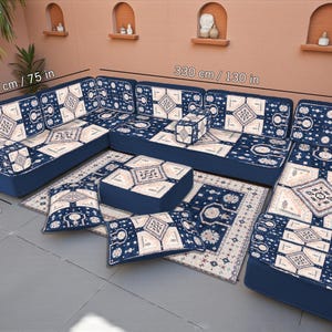 May include: A U-shaped sectional sofa set with a patterned design in navy blue and cream. The set includes a large sofa, ottoman, rug, and throw pillows. The sofa is 130 inches long, 75 inches wide, and 28 inches high.