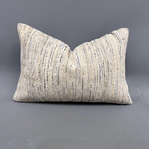 May include: A white and blue patterned throw pillow with a woven texture.