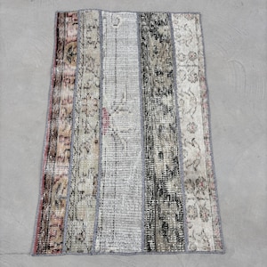 May include: A patchwork rug with six vertical strips of fabric in various shades of beige, brown, and gray. The rug has a distressed, vintage look and is made from recycled materials.