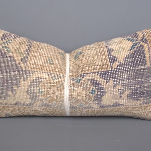 May include: A decorative pillow with a beige and blue patterned design. The pillow is made of woven fabric and has a fringed edge.