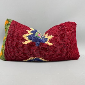 May include: A red, green, yellow, and blue patterned pillow with a woven texture.