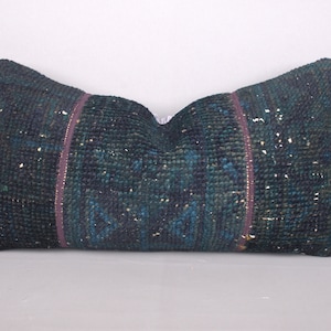 May include: A dark blue and green patterned pillow with a purple trim. The pillow is made of a soft, woven fabric.