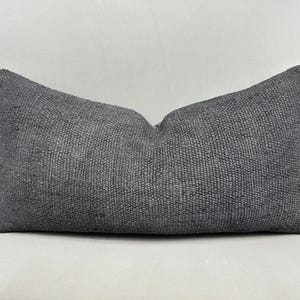 May include: A dark gray throw pillow with a textured woven fabric.