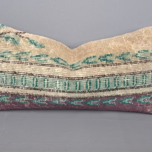 May include: A decorative cushion with a beige background and a colourful geometric pattern in shades of green, brown, and purple.