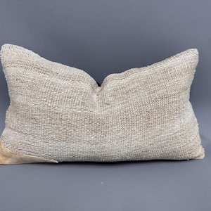 May include: A white, woven pillow with a textured surface. The pillow is rectangular and has a slightly rounded shape.