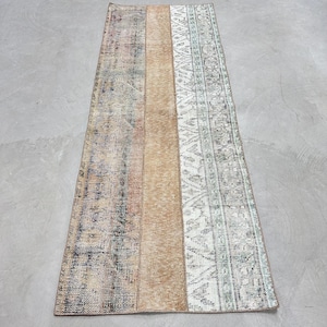 May include: A vintage rug with a striped design in shades of brown, beige, and white. The rug has a faded, distressed look and is made of woven fibers.