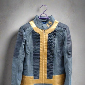 May include: A blue leather jacket with gold accents and a zipper closure. The jacket has a high collar and a  "3" embroidered on the collar.
