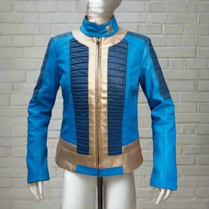 May include: A blue and gold leather jacket with a zipper closure and a stand-up collar. The jacket has a vertical panel of gold leather down the front and a blue panel on each side. The jacket has a small gold emblem on the collar.
