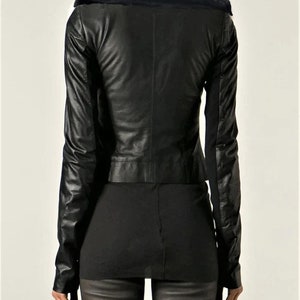 May include: Black leather jacket with a faux fur collar. The jacket has a cropped fit and long sleeves.