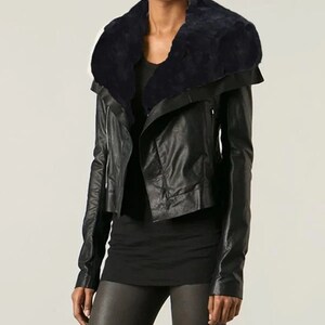 May include: A black leather jacket with a large, black fur collar. The jacket has a zipper closure and a slightly cropped length.
