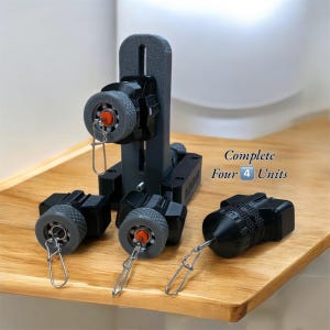 Könnte beinhalten: Ein Set aus vier schwarzen Einheiten mit grauen Rädern und roten Akzenten, zusammen mit einer vertikalen Stützstruktur. Die Einheiten haben silberne Clips. Der Text "Complete Four 4 Units" ist sichtbar.