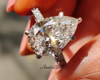 Anillo de compromiso con moissanita talla pera de 3,0 quilates, halo oculto y pavé de oro blanco de 18 quilates.