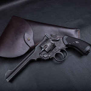 May include: A black revolver with a brown leather holster. The revolver has a black handle and a silver barrel.