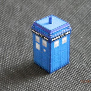 以下が含まれることがあります： 両側に「Police Box」と書かれた青い紙製の警察ボックスのモデル。モデルの上部には小さなアンテナがあります。
