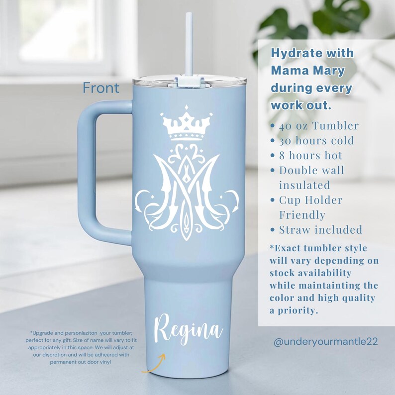 Op de afbeelding: Een lichtblauwe beker van 1,18 liter met een wit kroon- en monogramontwerp, een handvat en een rietje. Het woord "Regina" staat op de beker. De tekst "Hydrate with Mama Mary during every work out" is ook zichtbaar.