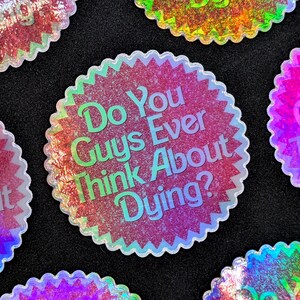 K&ouml;nnte beinhalten: Ein Satz von f&uuml;nf schimmernden Aufklebern mit einem rosa Glitzerhintergrund und wei&szlig;em Text. Der Text auf den Aufklebern lautet "Do You Guys Ever Think About Dying?"