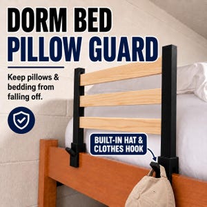 May include: A dorm bed pillow guard featuring three horizontal light wood slats held by two black vertical supports. The text reads DORM BED PILLOW GUARD, Keep pillows & bedding from falling off, and BUILT-IN HAT & CLOTHES HOOK with a hook.