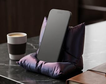 Suporte/apoio para celular exclusivo, impresso em 3D, em formato de "almofada fofa", nas cores vermelho e preto.