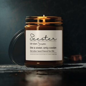 May include: A brown glass candle jar with a white label that reads "Seester Ise-starl Susan like a sister, only cooler. See also: best friend for life".