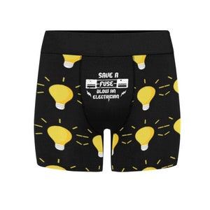 May include: Black boxer briefs with a repeating pattern of yellow light bulbs with radiating lines. The waistband is black. The front of the briefs has the text "SAVE A FUSE BLOW AN ELECTRICIAN".