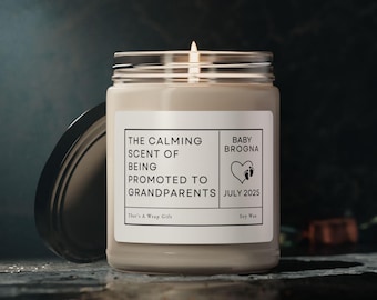 May include: A beige soy candle with a white label that reads "The calming scent of being promoted to grandparents, Baby Brogna July 2025".