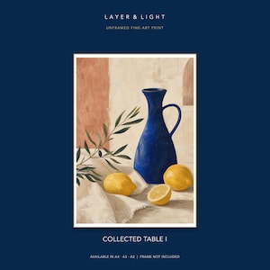 K&ouml;nnte beinhalten: Ein Kunstdruck mit dem Titel LAYER & LIGHT COLLECTED TABLE I, der einen blauen Krug, drei gelbe Zitronen und einen Olivenzweig auf einem wei&szlig;en Tuch zeigt. Der Hintergrund zeigt eine strukturierte Wand in Creme- und Terrakottat&ouml;nen. Ungerahmter Druck.