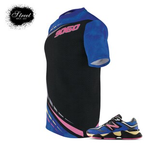 Puede incluir: Una camiseta de manga corta negra y azul con un dise&ntilde;o gr&aacute;fico rosa y amarillo y el n&uacute;mero "9060" impreso en la parte delantera. Un par de zapatillas azules, negras y amarillas con un logotipo "N" blanco.
